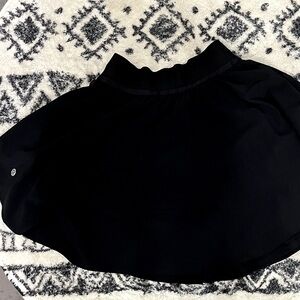 Lululemon black flowy tennis skirt with built-in shorts. Size 2.